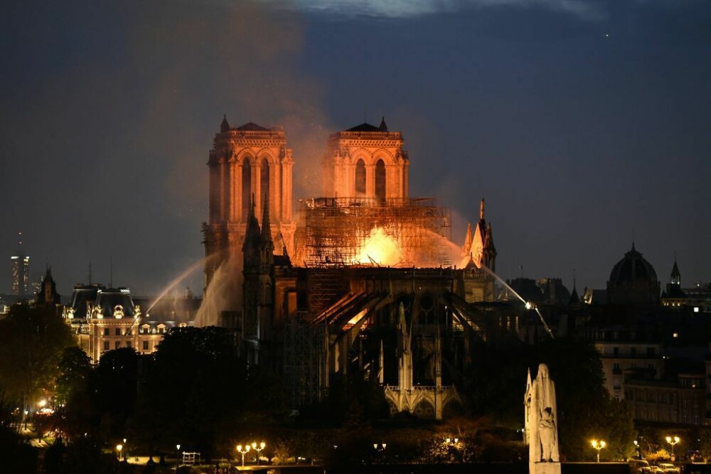 Momentul în care parizienii, devastați de incendiul de la Notre Dame, încep să cânte imnuri - Imaginea 1