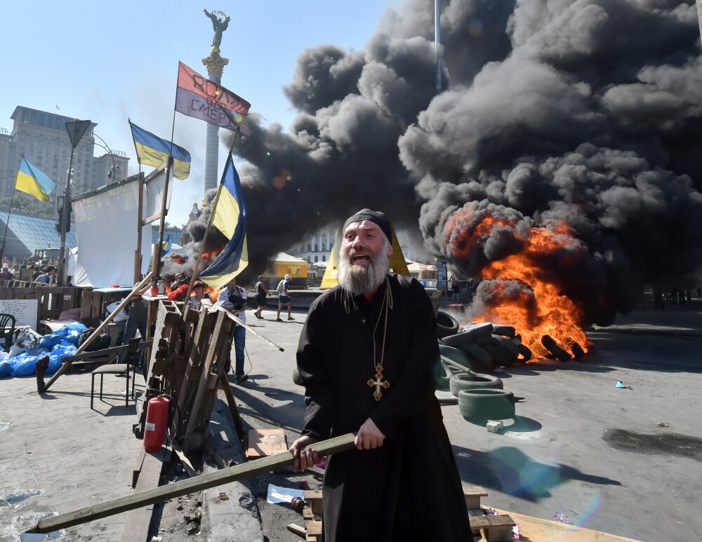 Euromaidanul, din nou in flacari. Preotul care arunca sticle incendiare, personajul zilei in noile proteste de la Kiev - Imaginea 1