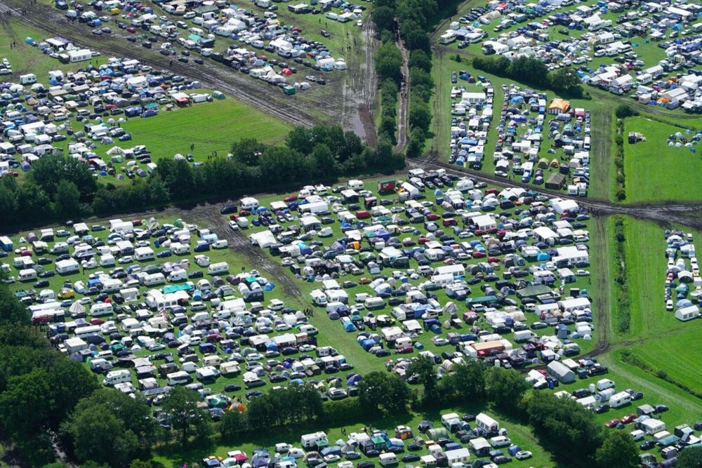 Condiţii meteo infernale la cel mai mare festival rock din lume. Mașinile petrecăreților au rămas blocate în noroi. FOTO - Imaginea 7