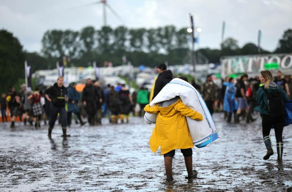 Condiţii meteo infernale la cel mai mare festival rock din lume. Mașinile petrecăreților au rămas blocate în noroi. FOTO - Imaginea 10