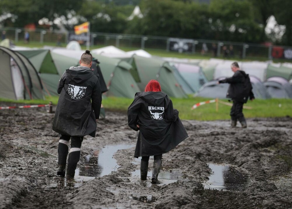 Condiţii meteo infernale la cel mai mare festival rock din lume. Mașinile petrecăreților au rămas blocate în noroi. FOTO - Imaginea 11