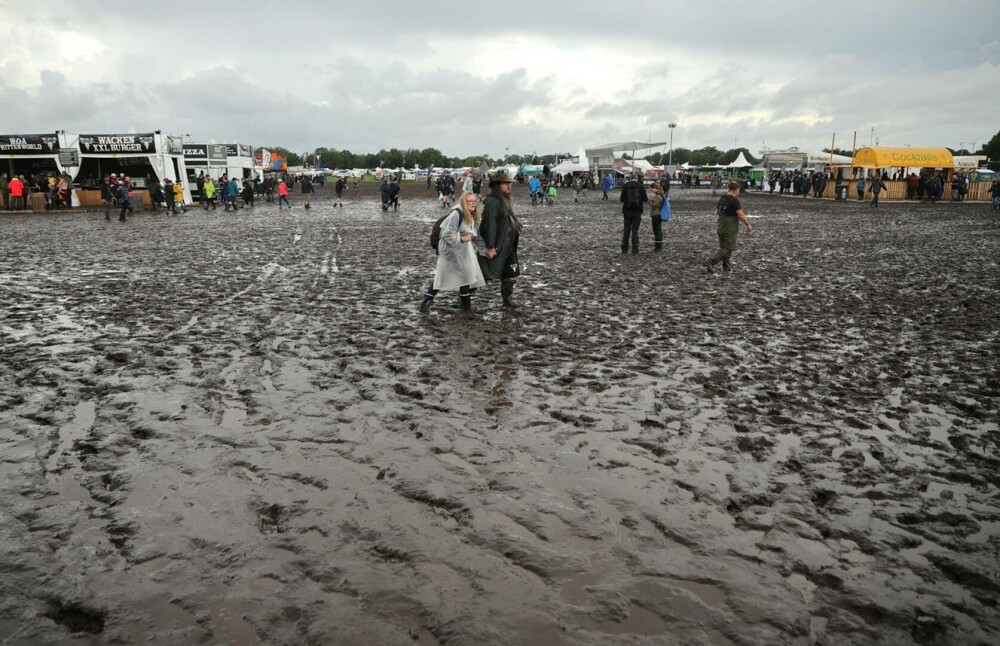 Condiţii meteo infernale la cel mai mare festival rock din lume. Mașinile petrecăreților au rămas blocate în noroi. FOTO - Imaginea 12