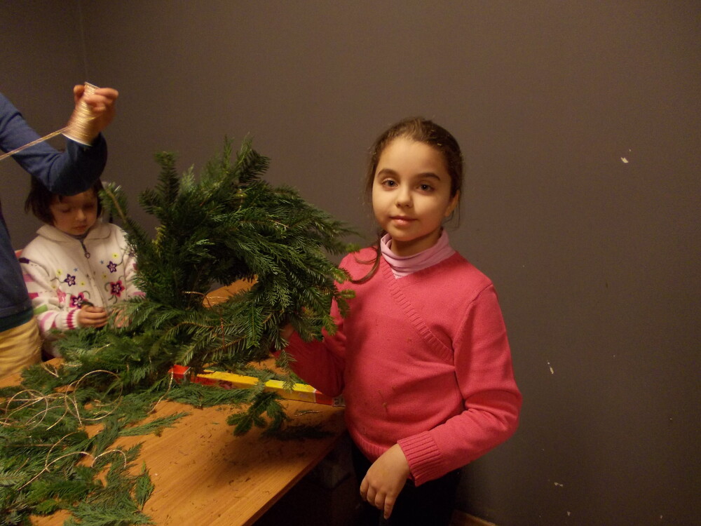 Pregatiri pentru sarbatorile de iarna. Cativa copii au impletit coronite de brad. FOTO - Imaginea 3