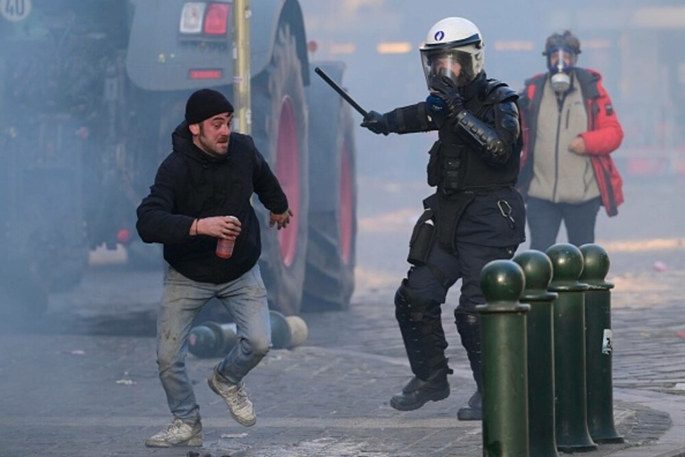Protest violent în Bruxelles. Mii de fermieri au ieșit în stradă, polițiștii au folosit tunurile cu apă și gaze lacrimogene - Imaginea 13