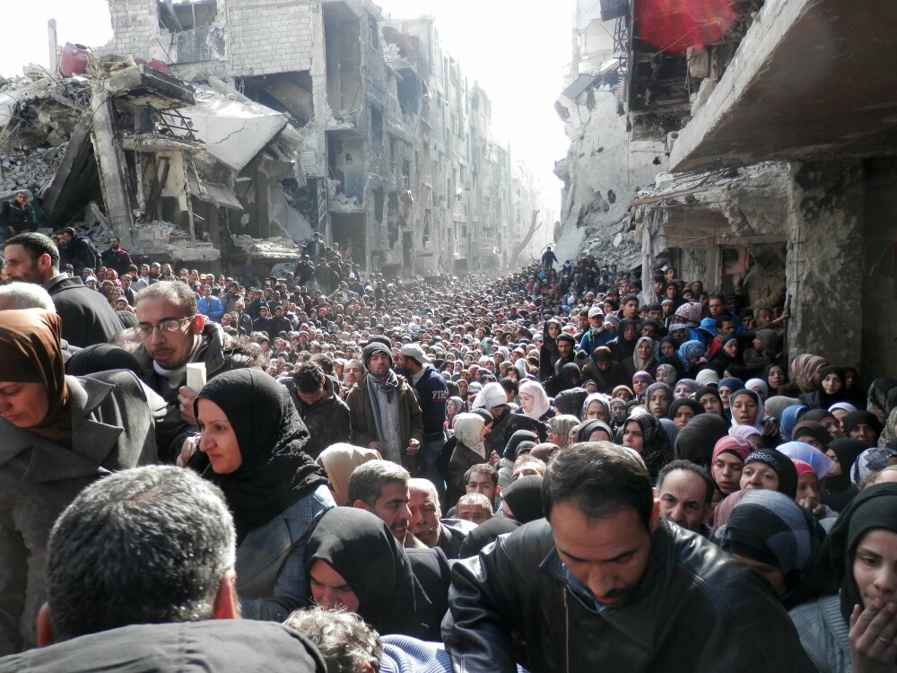 Poza care arata dimensiunea crizei umanitare din Siria. Coada nesfarsita pentru mancare intr-o tabara de refugiati din Damasc - Imaginea 1