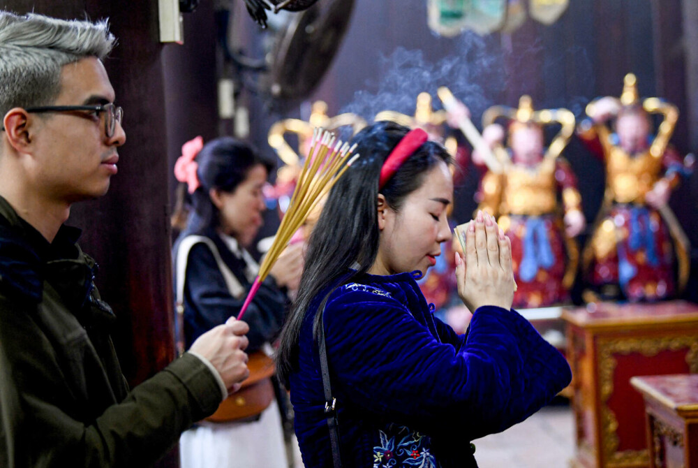„Mă rog deja de cinci ani aici”. De Ziua Îndrăgostiţilor, tinerii singuri din Vietnam se roagă pentru a-şi găsi jumătatea - Imaginea 1