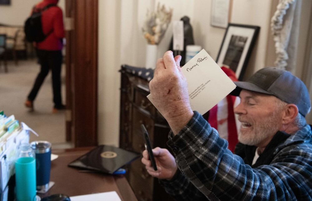 Cine este bărbatul care s-a urcat cu bocancii pe biroul lui Nancy Pelosi și i-a furat un plic - Imaginea 2