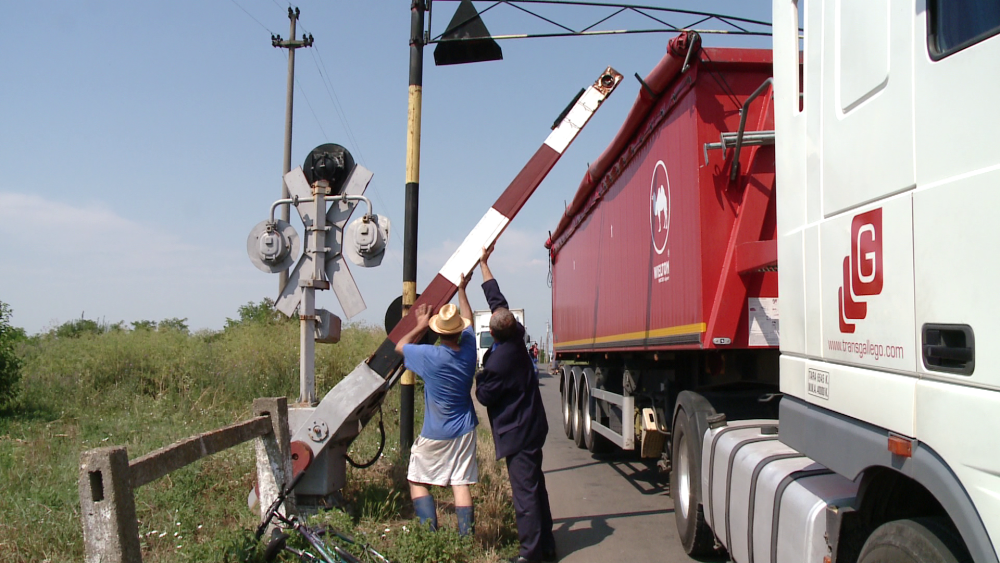 Un sofer a ignorat semnalele de la o trecere de cale ferata si s-a blocat cu TIR-ul sub bariera.FOTO - Imaginea 1