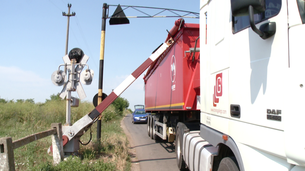 Un sofer a ignorat semnalele de la o trecere de cale ferata si s-a blocat cu TIR-ul sub bariera.FOTO - Imaginea 2