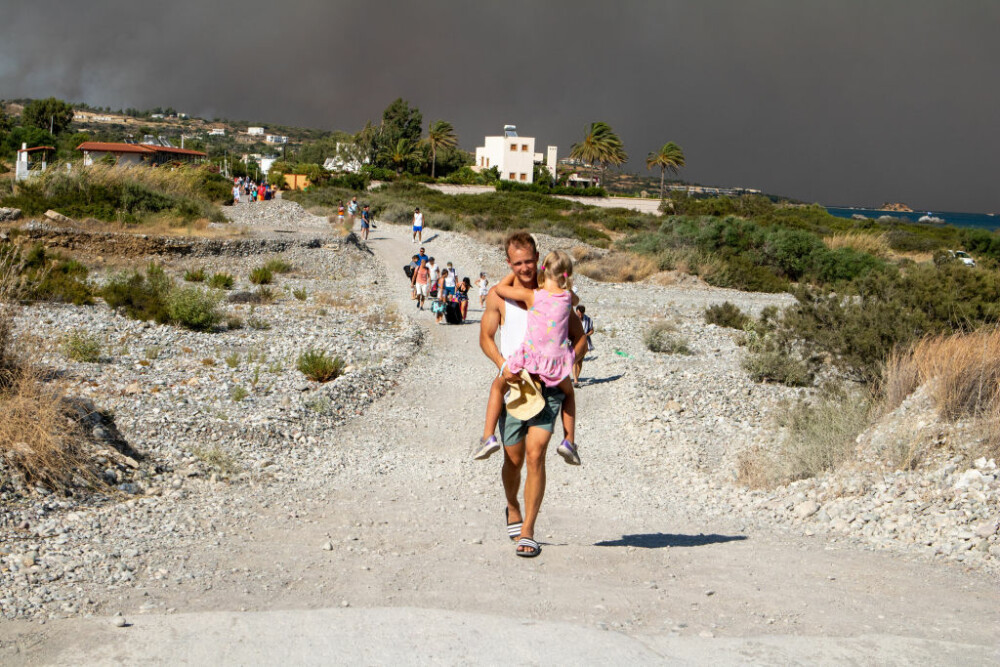 Imagini apocaliptice pe insula Rodos din Grecia, din cauza incendiilor. Oameni cu valize în brațe, căutând refugiu - Imaginea 6