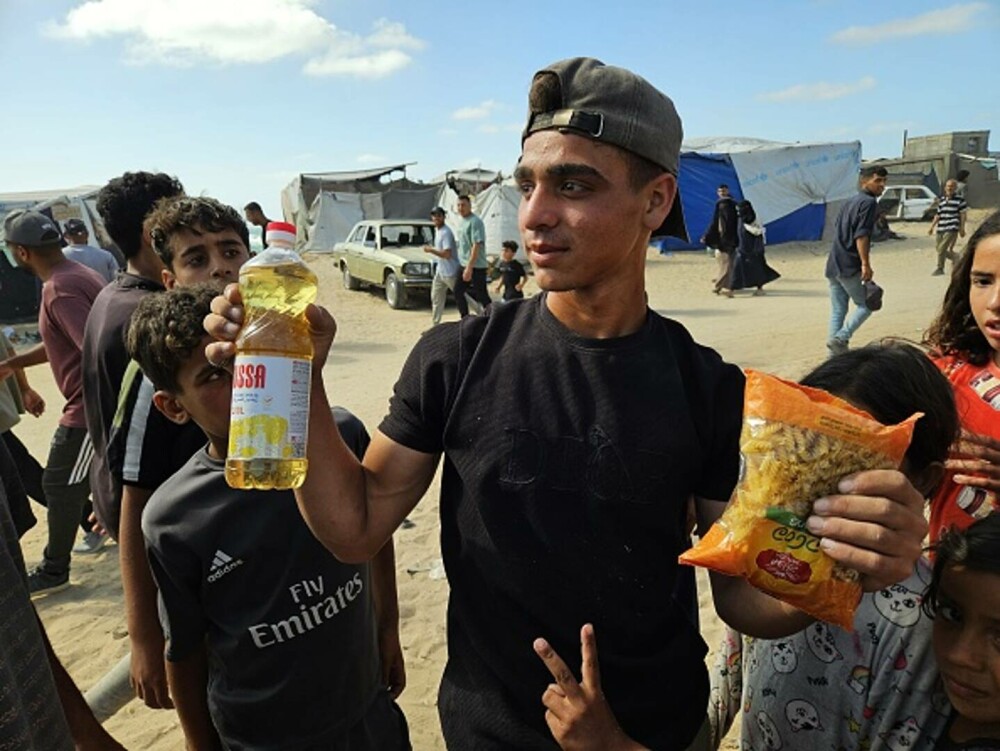 Haos la un centru de distribuţie de alimente din Gaza. Mii de palestinieni înfometați au năvălit pentru a prinde mâncare - Imaginea 8