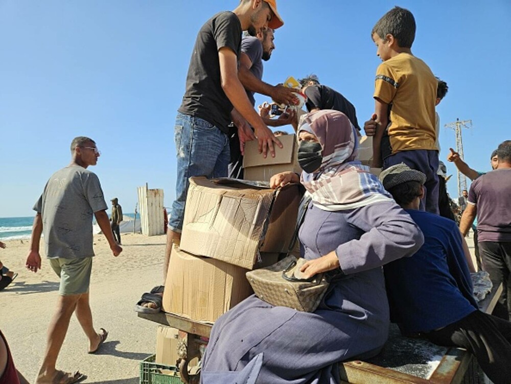 Haos la un centru de distribuţie de alimente din Gaza. Mii de palestinieni înfometați au năvălit pentru a prinde mâncare - Imaginea 9