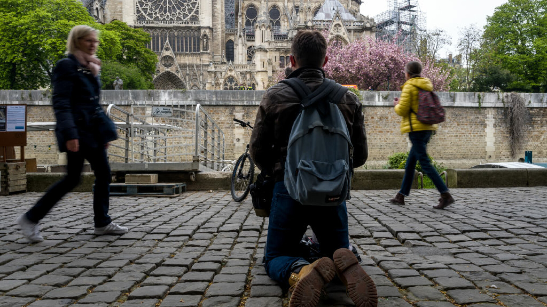 Un parizian, surprins în timp ce se roagă în genunchi în fața Catedralei Notre Dame
