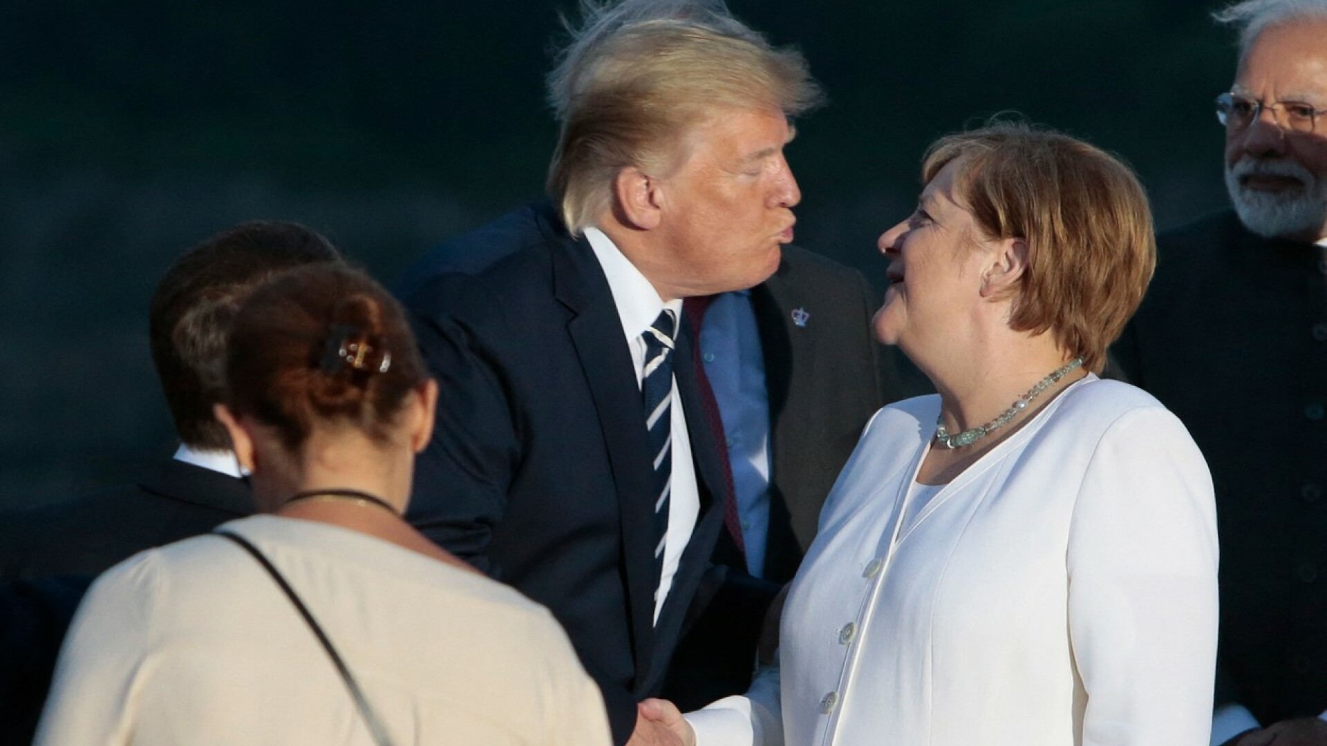Trump și-a țuguiat buzele pentru a o pupa pe Merkel, la summitul G7 din Franța
