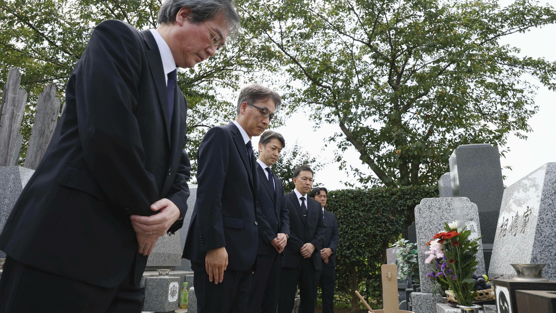 oameni inclinati mormant japonia