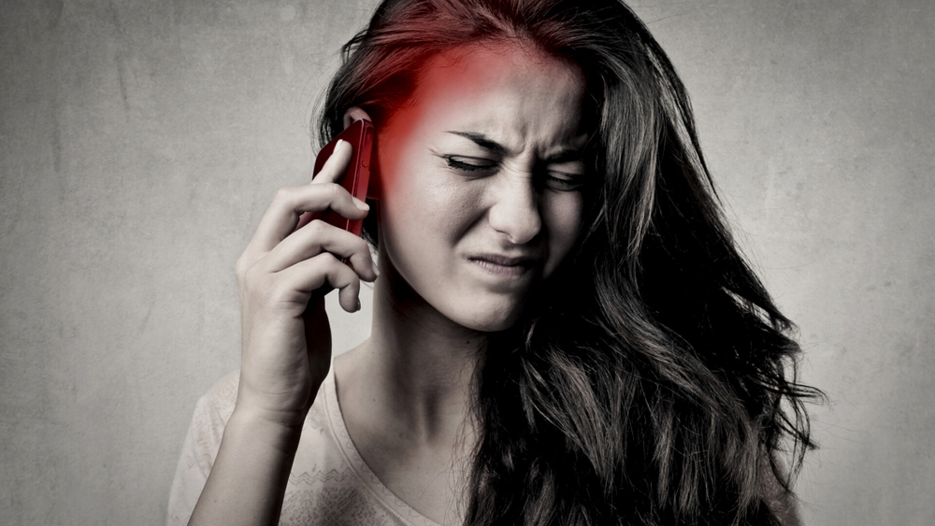 femeie care vorbeste la telefon si o doare capul