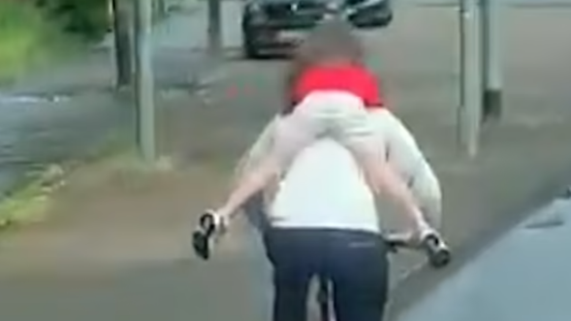 Un bărbat a fost surprins mergând pe bicicletă cu un copil agățat de gât, punându-i astfel viața în pericol