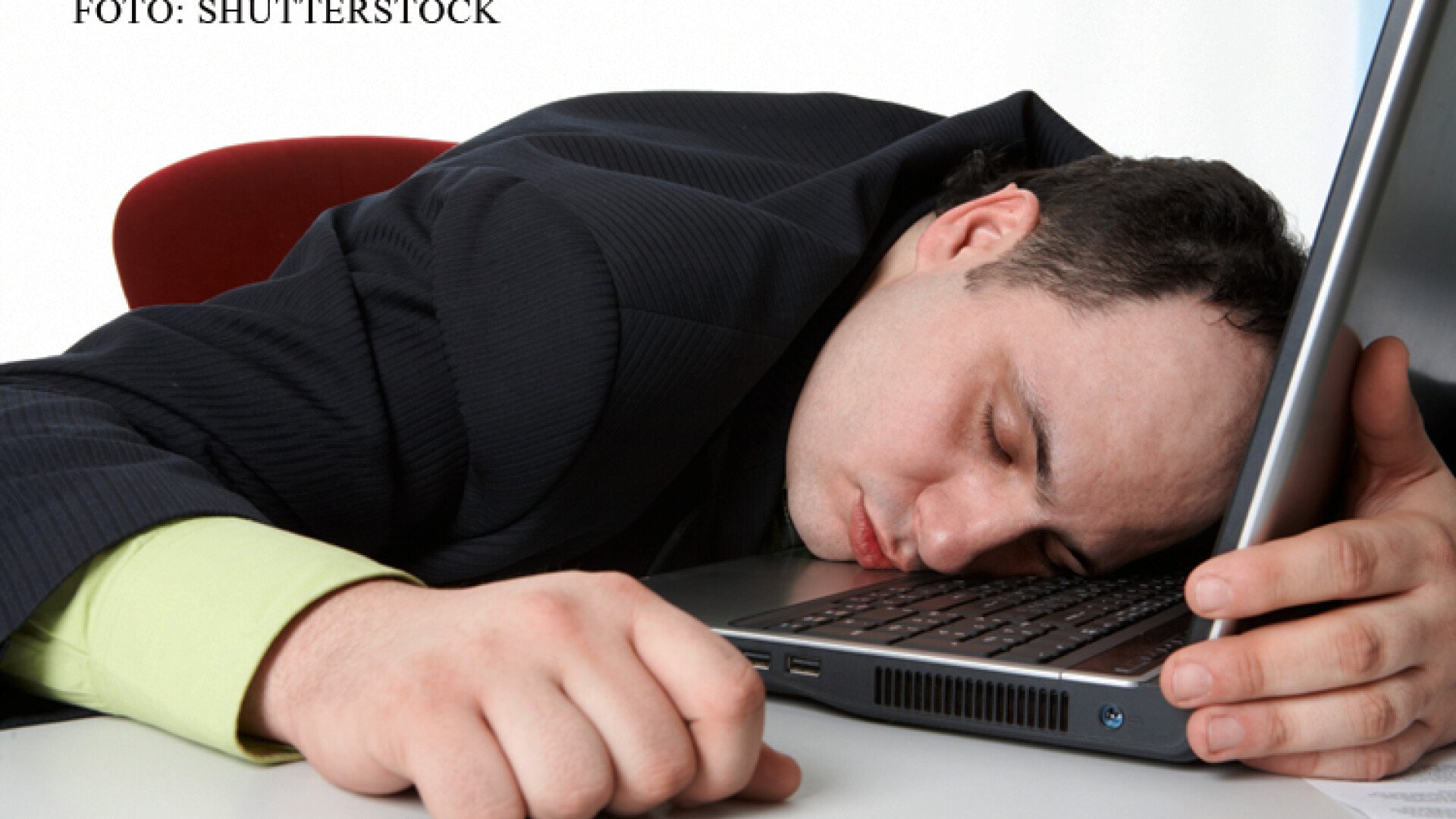 barbat care doarme cu capul pe laptop