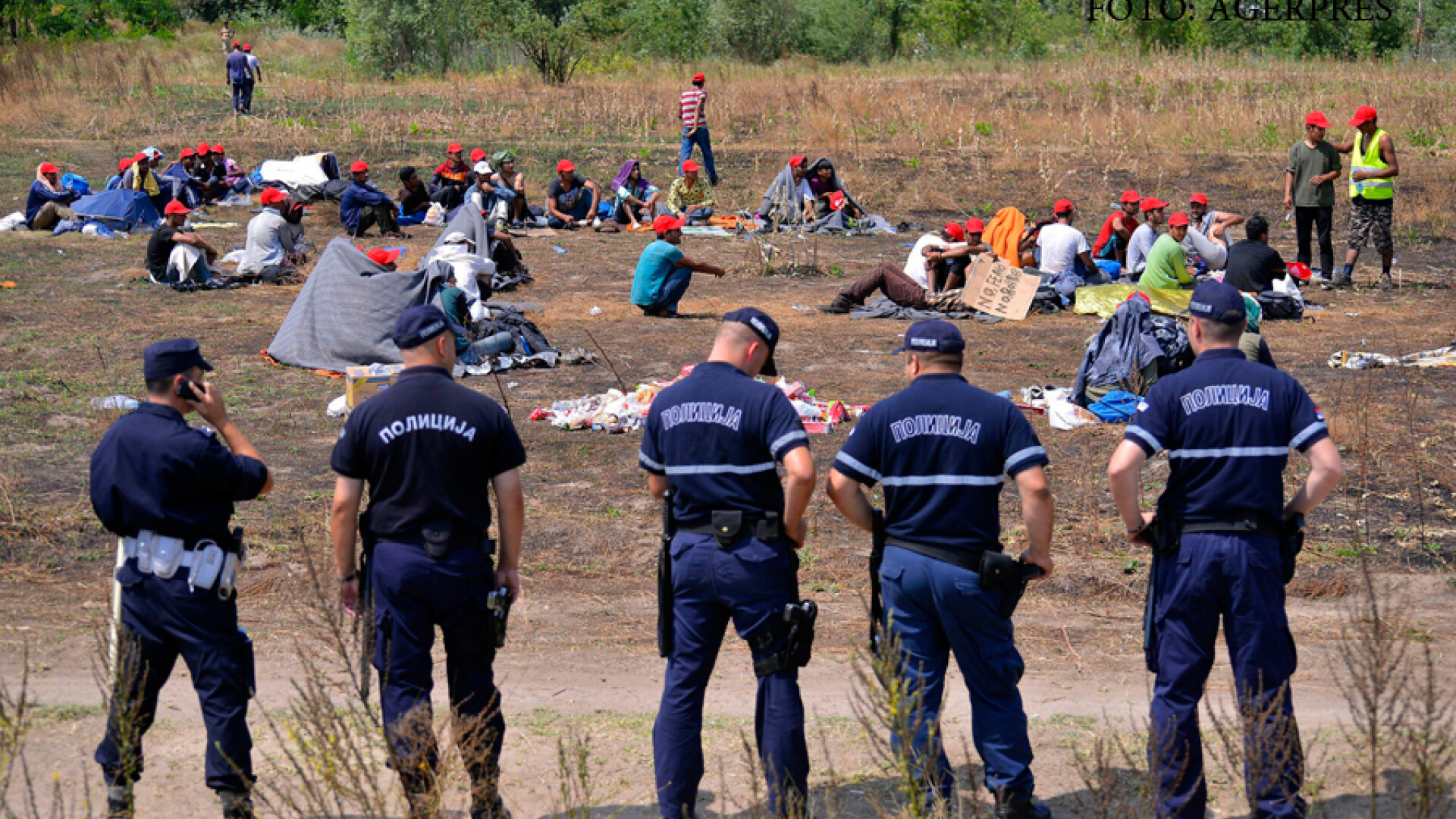 politisti sarbi supraveghin o tabara de migranti
