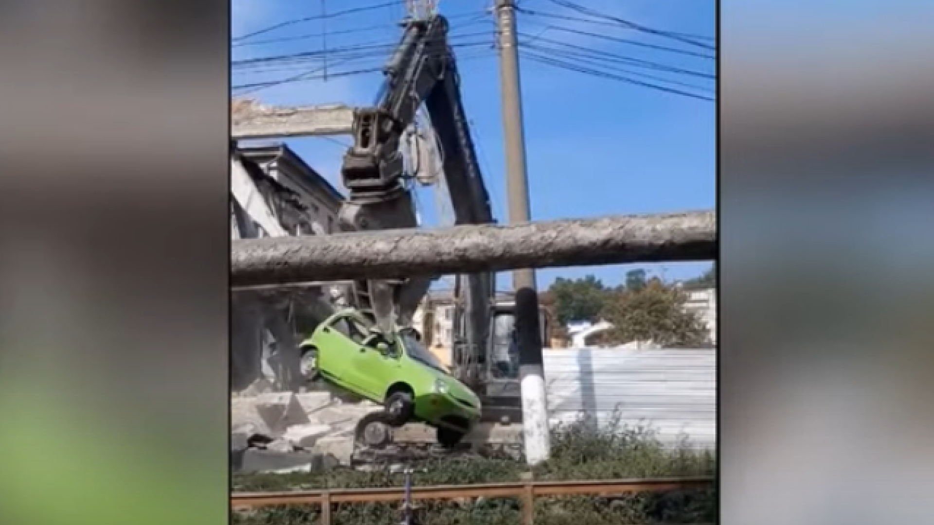 Mașină ridicată de un excavator și mutată peste gard, pe un șantier din Chișinău VIDEO