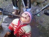 Imaginea socanta a unui razboi sangeros sau unealta de propaganda? Un copil, in genunchi, amenintat de rebeli sirieni