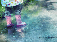 ploaie, copil care se joaca in balti FOTO SHUTTERSTOCK