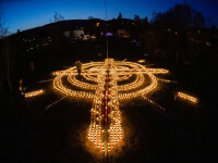 A făcut o cruce uriașă din candele, în curtea sa, în memoria victimelor răpuse de Covid-19. GALERIE FOTO