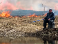 Un bărbat pescuia liniștit în timp ce câmpul ardea în spatele lui. ”Nu e nimic nou aici”