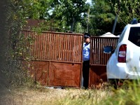 Politisti de la criminalistica verifica terenul din curtea casei inculpatului Gheorghe Dinca