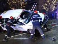 Taxi răsturnat pe o stradă din Baia Mare. Autoturismul a lovit o bordură și a rupt un copac