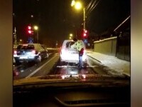 Polițiștii care s-au bătut cu zăpadă au recidivat: au deszăpezit luneta unui șofer, în trafic