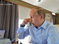 Vladimir Putin vorbind la telefon in avion