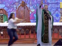 Momentul în care o femeie împinge un preot de pe scenă, în timpul predicii