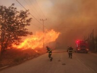 Nove villaggi vicino ad Atene sono stati evacuati da un incendio.  I vigili del fuoco rumeni aiutano a spegnere l'incendio