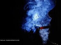 fumator in intuneric cu mult fum de tigara