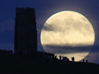 Luna plina, de culoare capsunei, deasupra Glastonbury Tor, la Solstitiul de vara