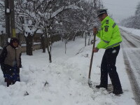 Bătrână izolată în curte din cauza zăpezii, ajutată de un polițist, în Gorj