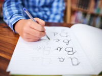 copil care scrie de mana
