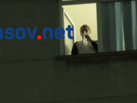 Bolnav de Covid cu masca de oxigen pe față privește de la geamul spitalului manifestanții anti-restricții