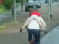 Un bărbat a fost surprins mergând pe bicicletă cu un copil agățat de gât, punându-i astfel viața în pericol