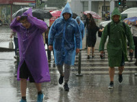 oameni pe strada ploaie