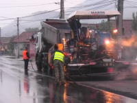 Asfaltare pe ploaie in orasul Dej. Motivul pentru care muncitorii au turnat tone de asfalt pe o strada cu balti. VIDEO