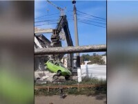 Mașină ridicată de un excavator și mutată peste gard, pe un șantier din Chișinău VIDEO
