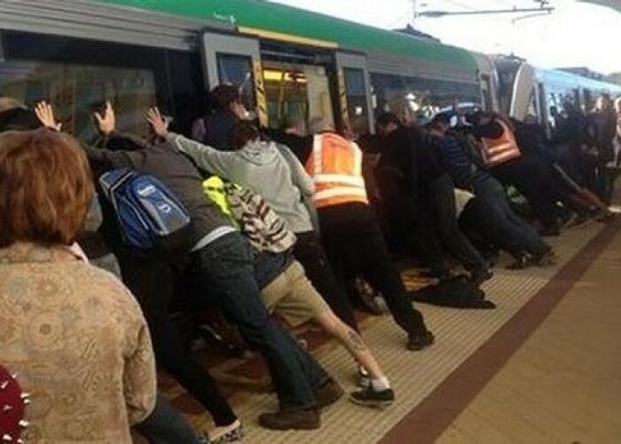 Clipul zilei: Zeci de pasageri au impins vagonul unui tren pentru a ajuta un barbat care cazuse! VIDEO