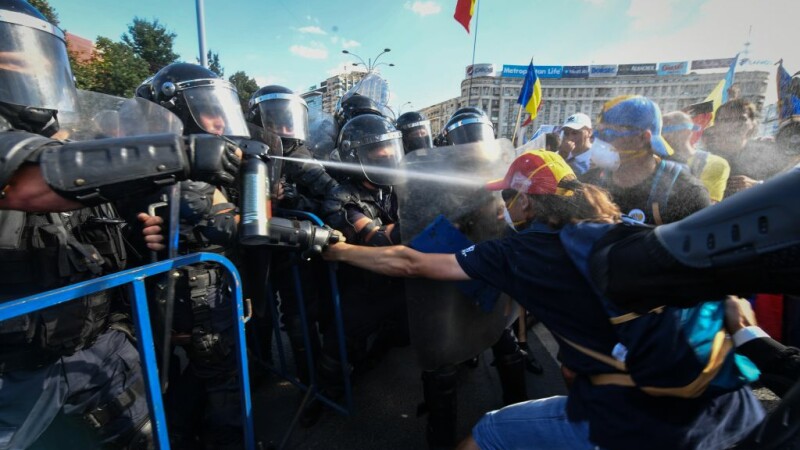 femeie stropita cu spray-ul lacrimogen