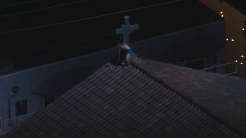 Un bărbat la bustul gol s-a urcat pe acoperișul unei biserici din SUA și a dat foc crucii