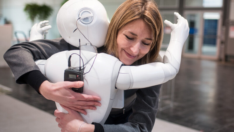 femeie imbratisand un robot