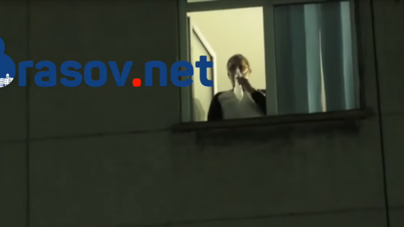 Bolnav de Covid cu masca de oxigen pe față privește de la geamul spitalului manifestanții anti-restricții