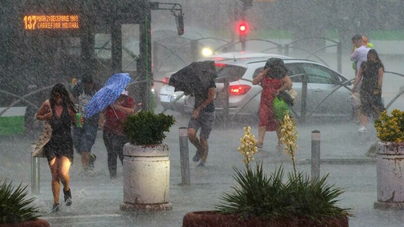 oameni pe strada ploaie