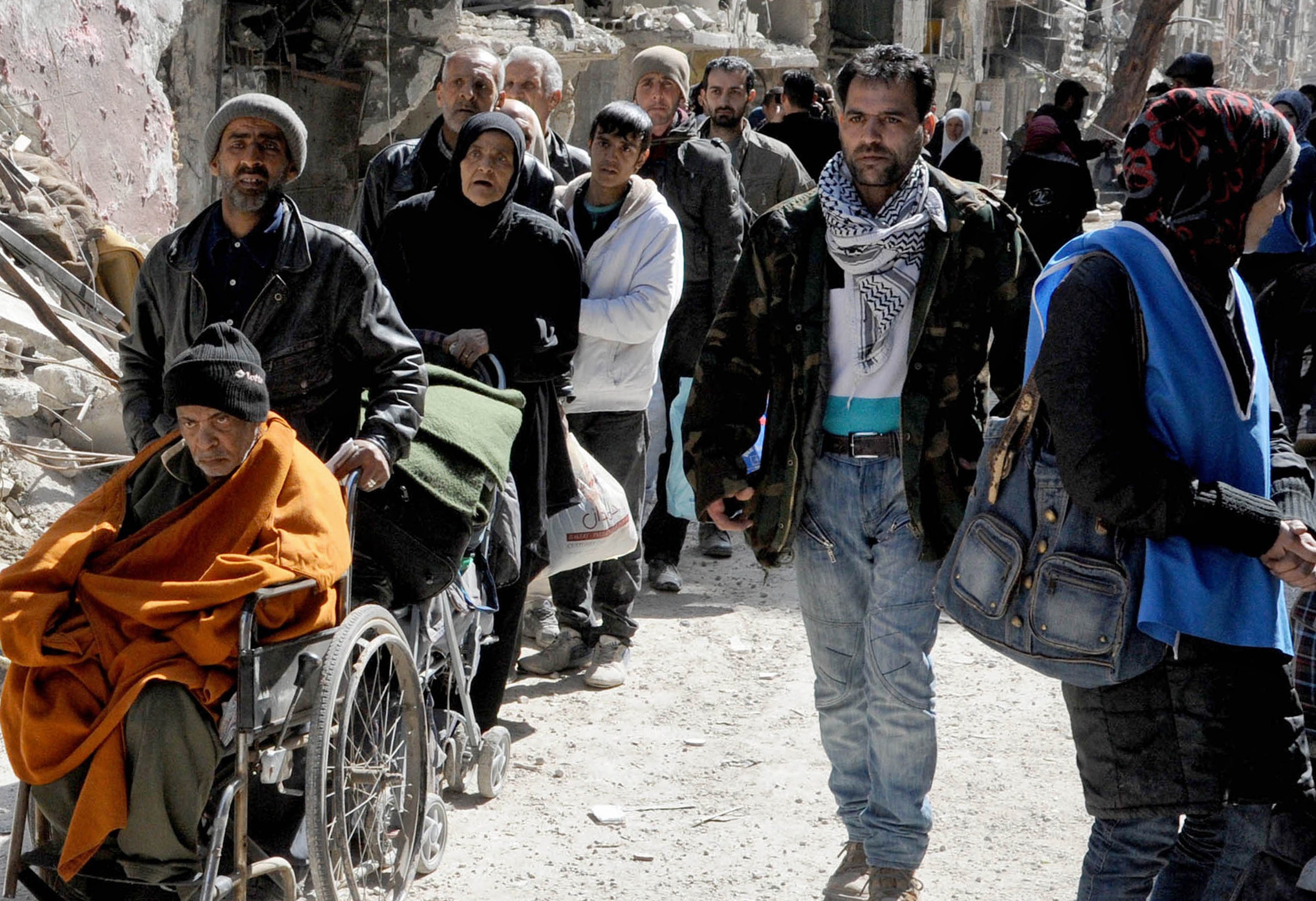Poza care arata dimensiunea crizei umanitare din Siria. Coada nesfarsita pentru mancare intr-o tabara de refugiati din Damasc - Imaginea 3